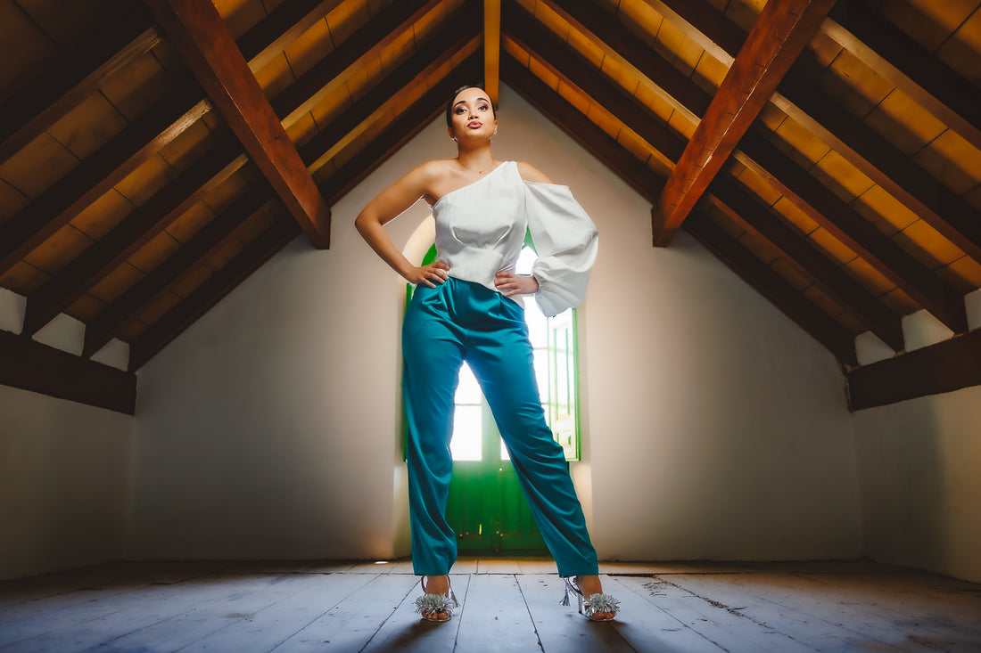 Mujer con pantalón verde esmeralda y blusa blanca 