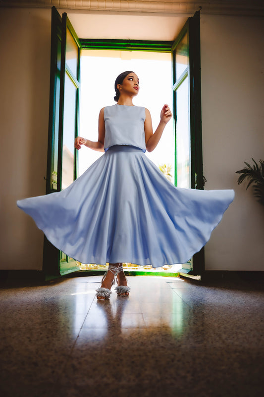 Mujer con un conjunto de top y falda de color azul bebé y confeccionado de tejido tencel marca podenco