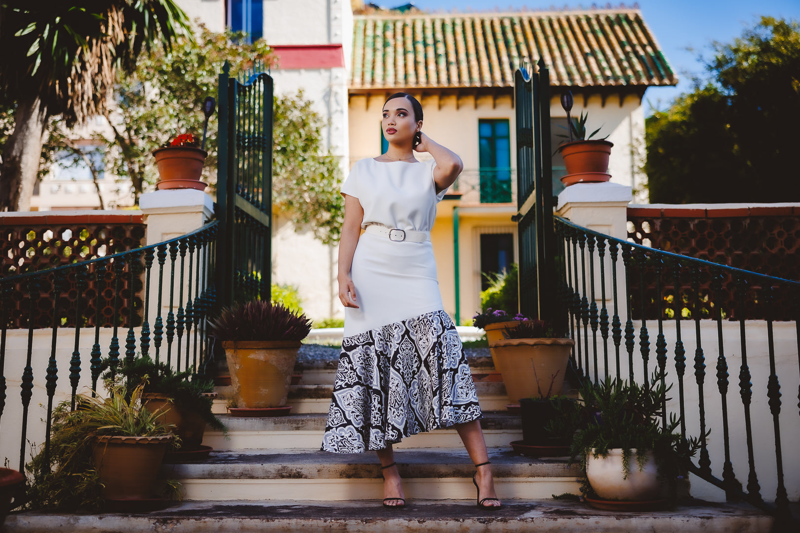 Mujer con vestido midi con un volante estampado y cinturón de piel marca podenco